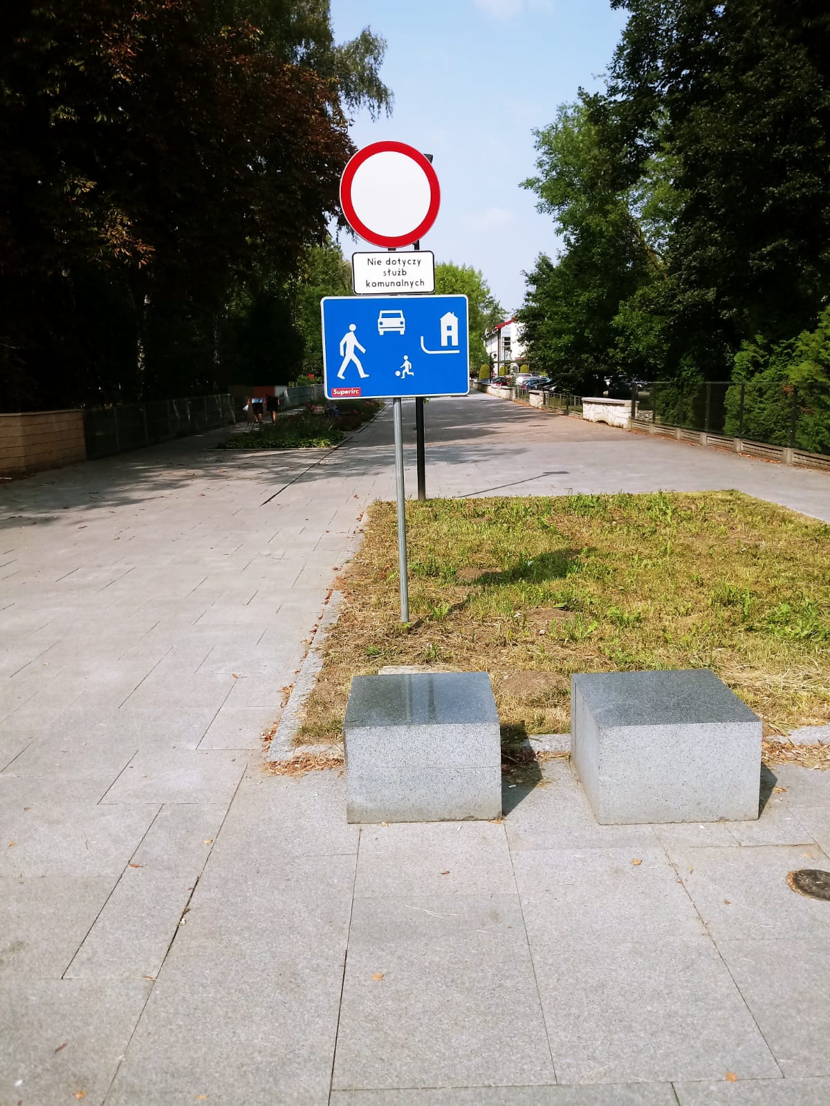 Znak drogowy B-1 „zakaz ruchu w obu kierunkach” pod nim tabliczka z napisem „Nie dotyczy służb ...